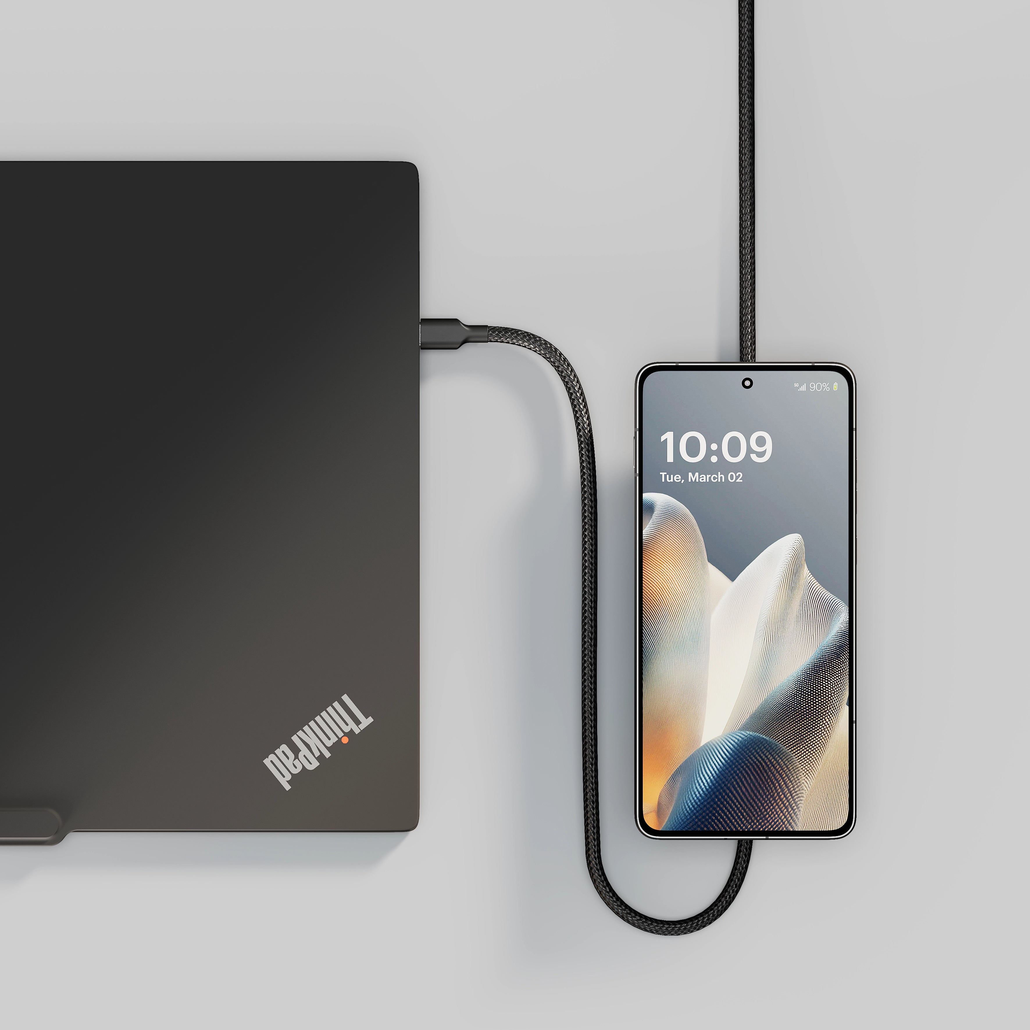 USB C Pro 2 charging cable charging a laptop and a smartphone.