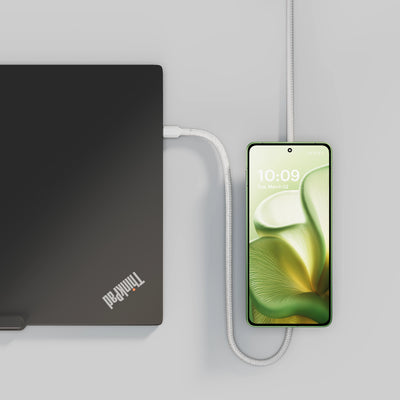 USB C Pro 2 charging cable charging a laptop and an smartphone in a lifestyle setting.