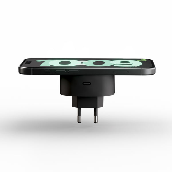 Plug in wireless magnetic charger charging a smartphone displaying a clock.