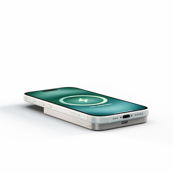 White Zens Semi Solid State Powerbank wirelessly and magnetically charging a smartphone.