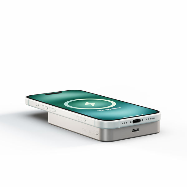White Zens Semi Solid State Powerbank wirelessly charging a smartphone.