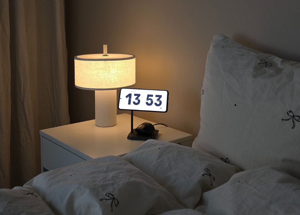 2 in 1 magnetic wireless charger for Samsung phone on a nightstand displaying the time