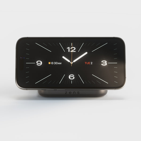 Zens Magnetic Nightstand Charger wirelessly and magnetically charging a smartphone displaying a clock.