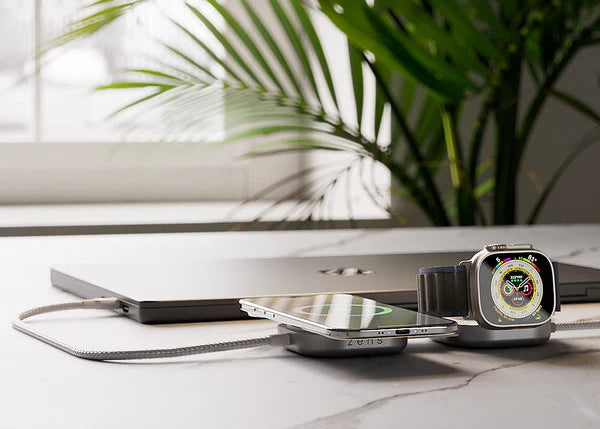 3 in 1 charging cable wirelessly charging an iPhone and smartwatch while charging a MacBook with a USB C cable in a home office