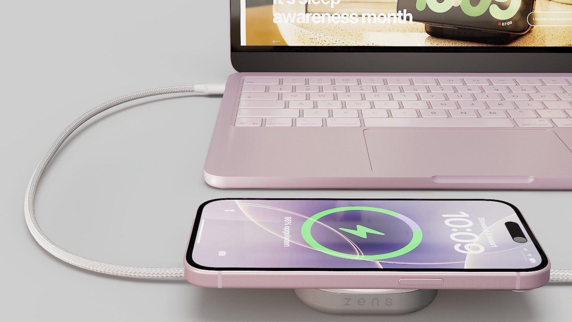 Wireless charging cable connected to a MacBook Neo charging an iPhone on a desk