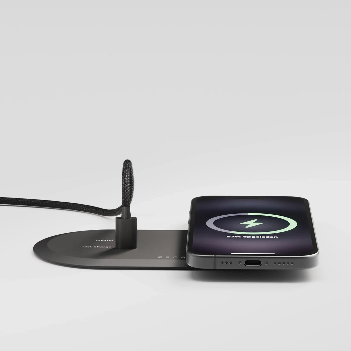 iPhone charging on a built in wireless charger while an HDMI cable connects a laptop to an external display and charges it 
