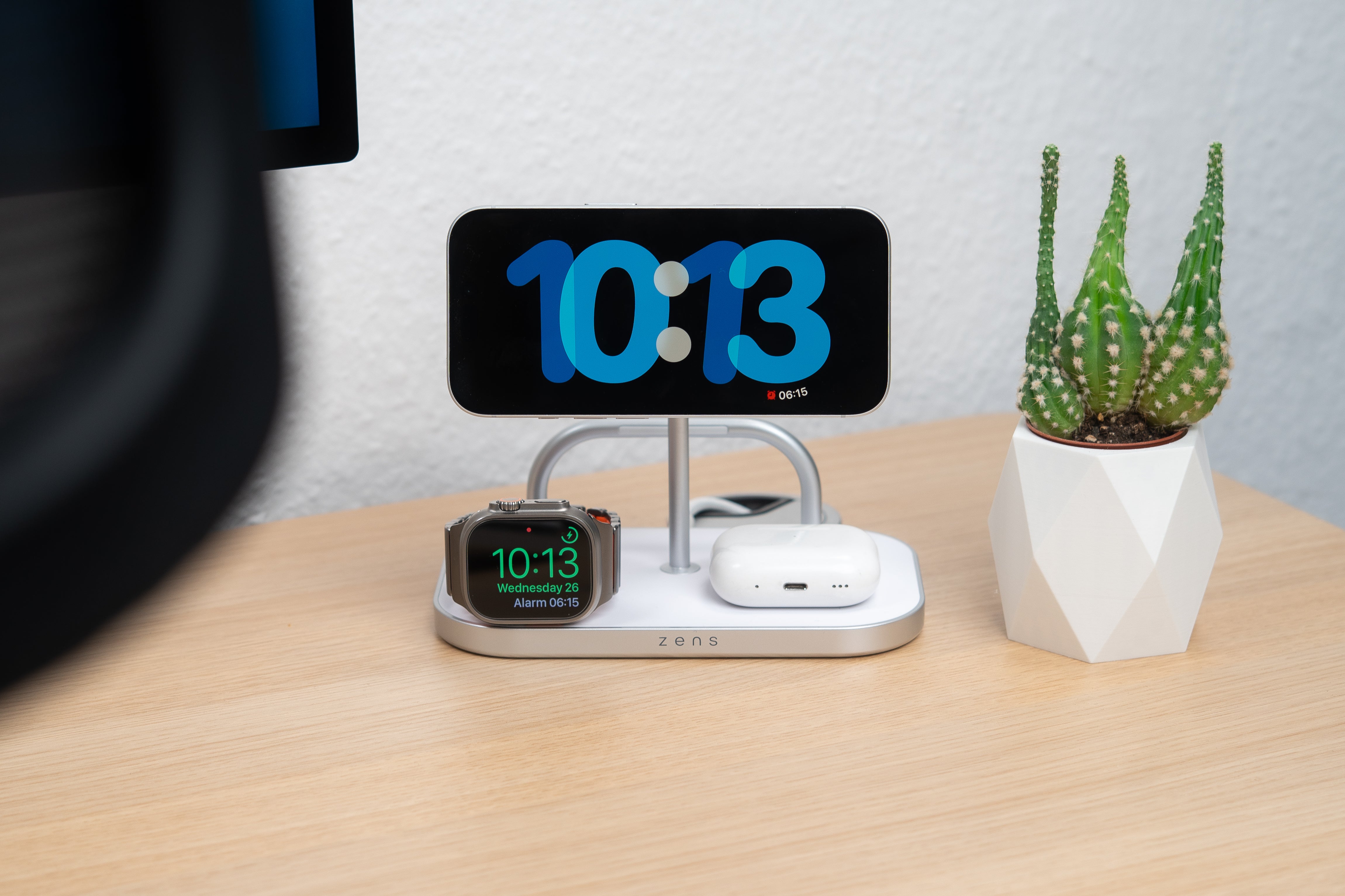 4 in 1 magnetic wireless charger charging a smartphone, AirPods, and Apple Watch in a lifestyle setting.