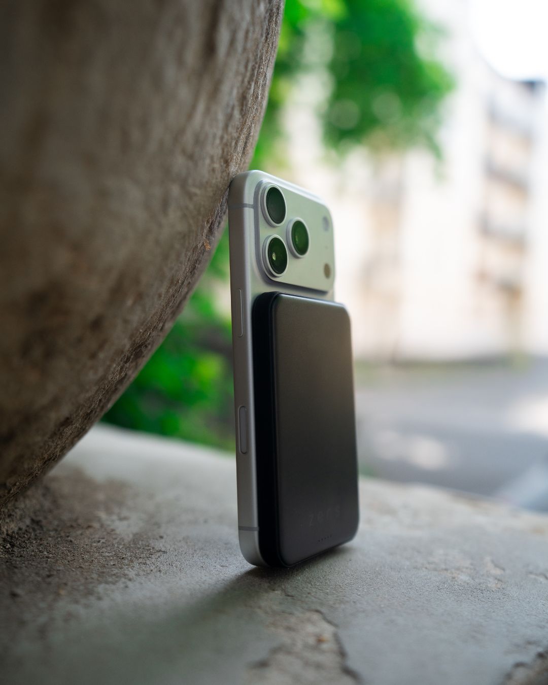 Black magnetic power bank attached to the back of an iPhone.