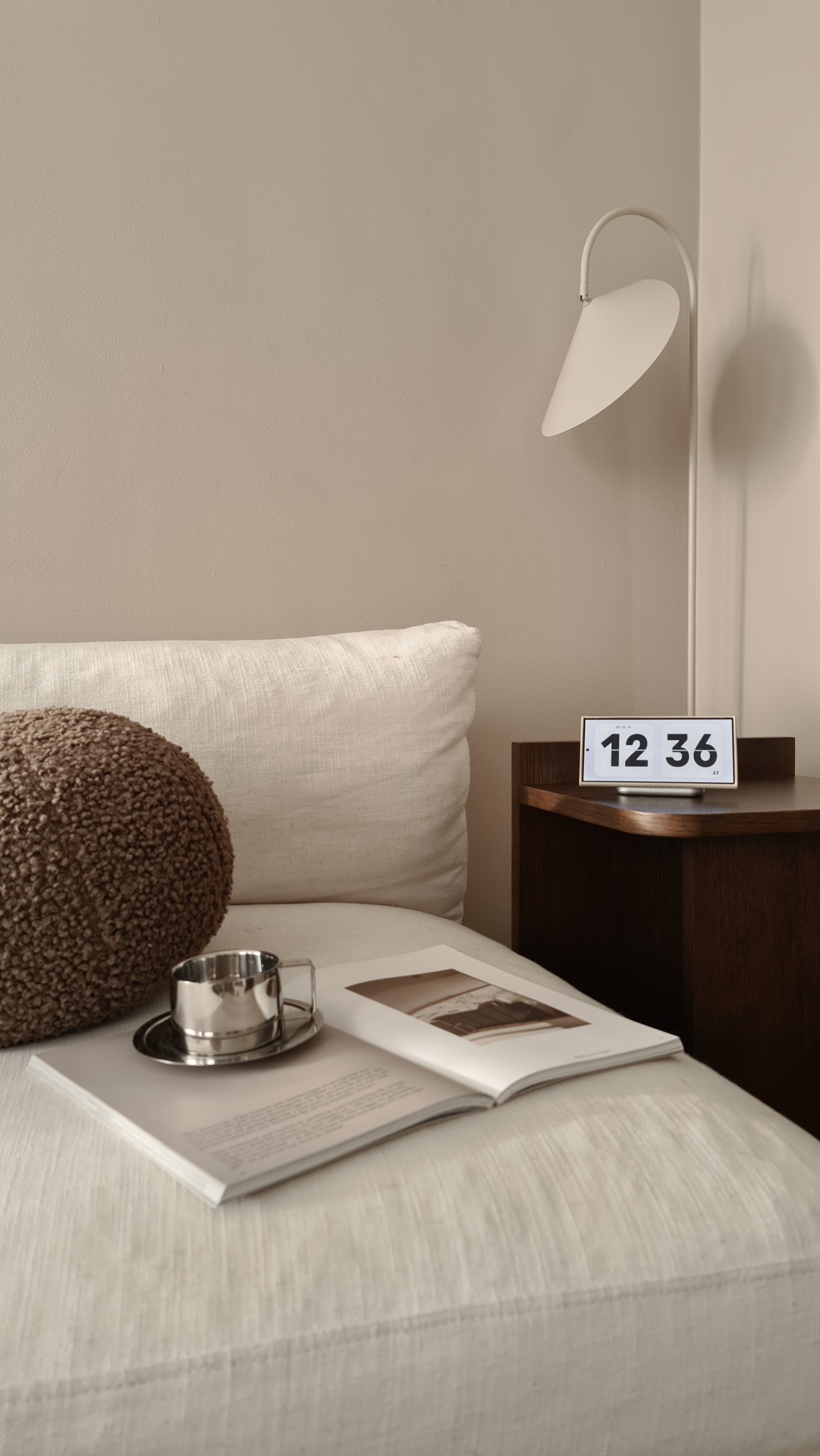 Zens magnetic wireless nightstand charger charging a Samsung phone displaying the time in a living room