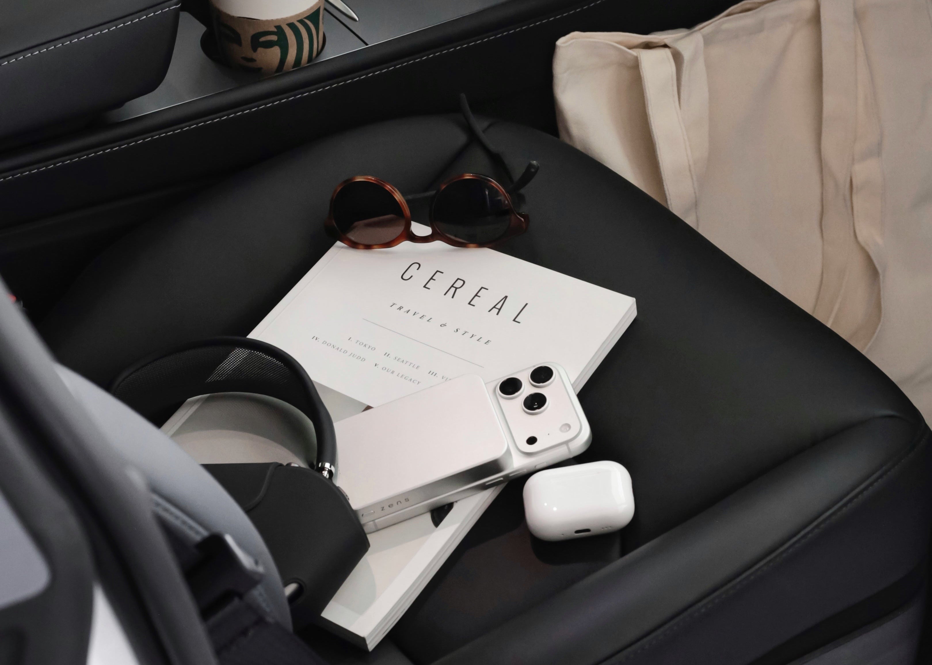 Zens powerbank charging an iPhone on a car seat with AirPods nearby