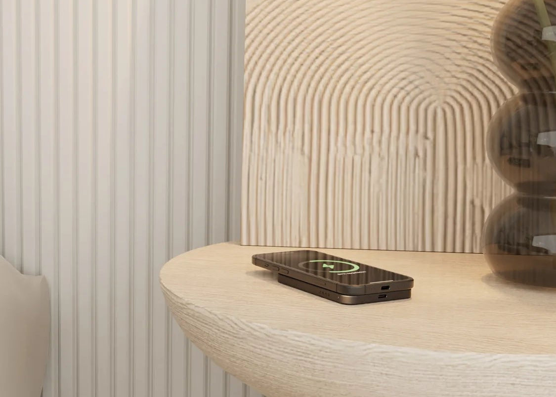 magnetische wireless powerbank black attached to an iPhone in a bedroom setting

