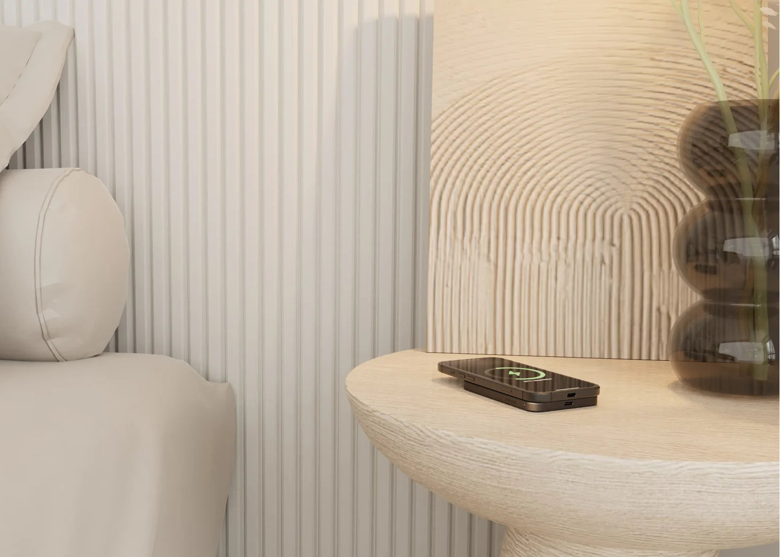 Black MagSafe power bank charging a smartphone on a bedroom nightstand.