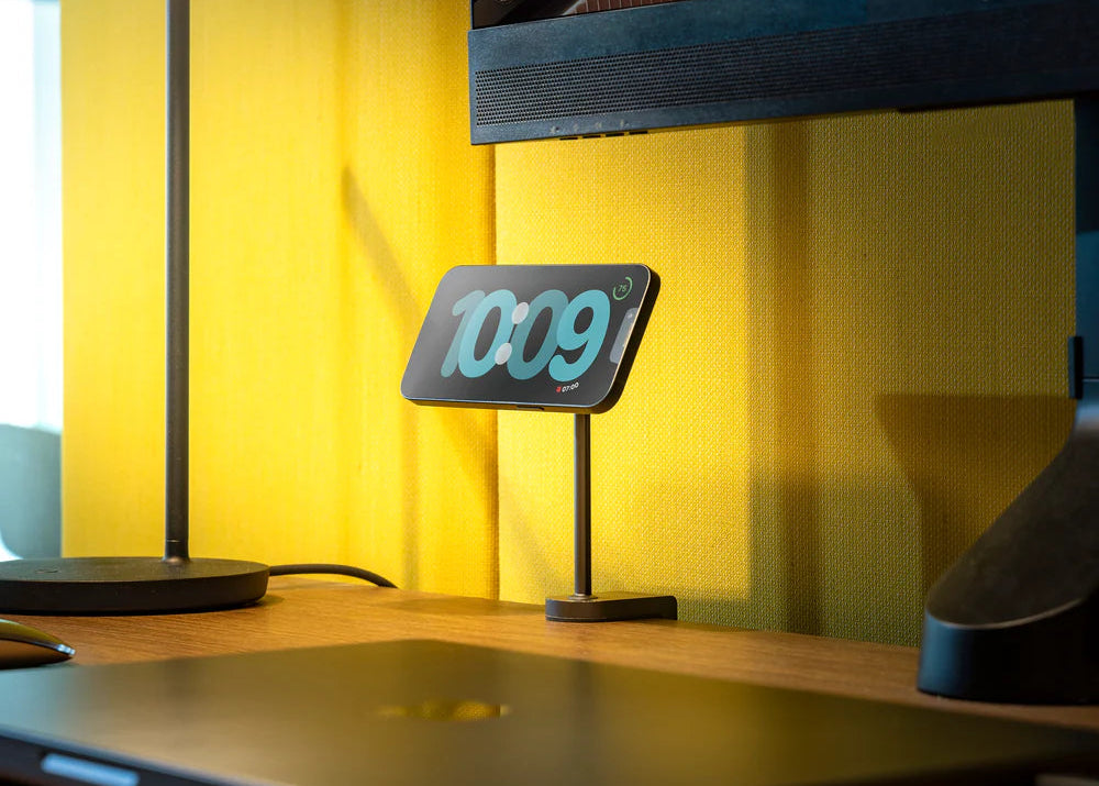 Zens MagSafe Mount Pro 2 wirelessly charging an iPhone displaying a clock in an office