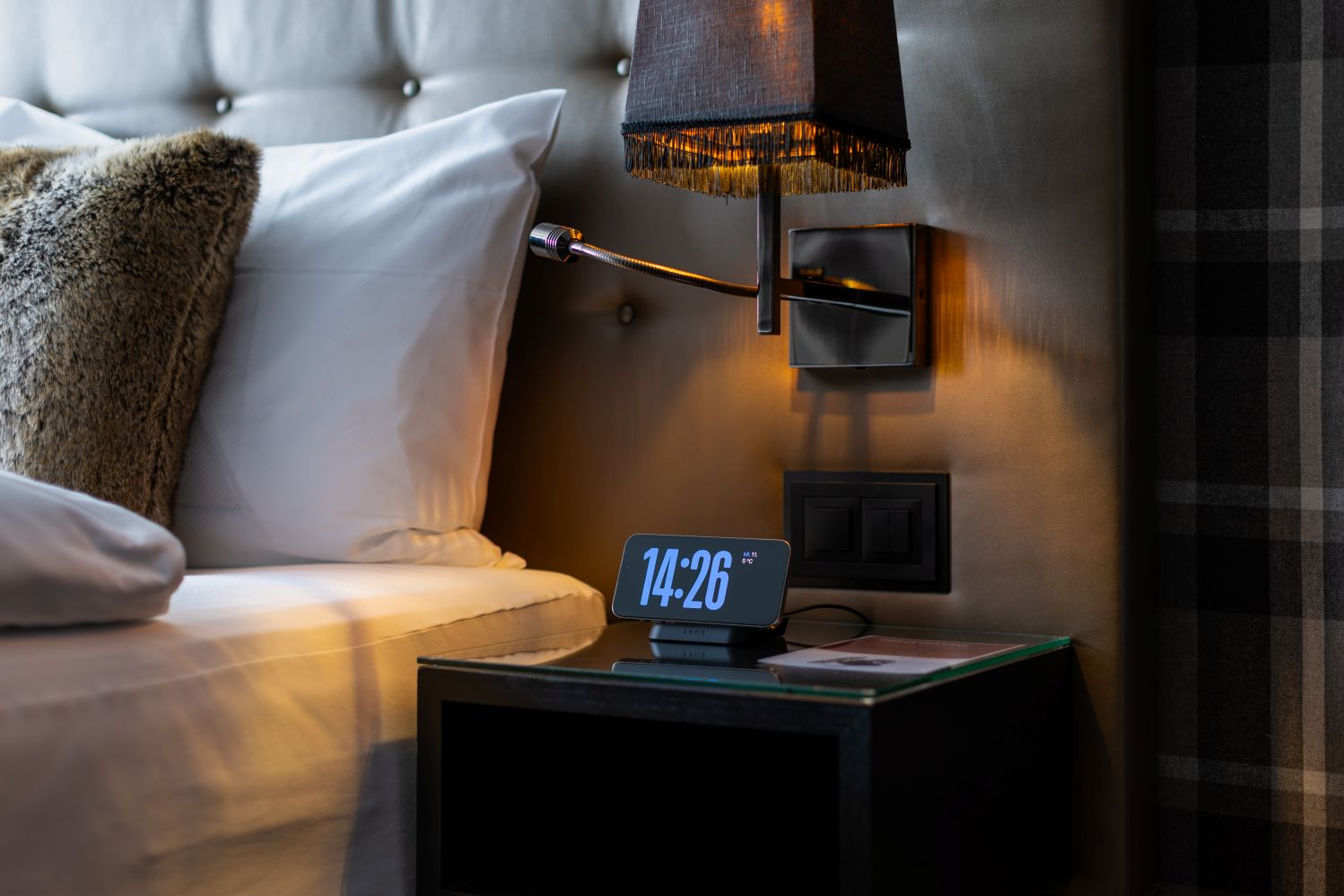 Magnetic nightstand wireless charger with clock charging an iPhone on a nightstand
