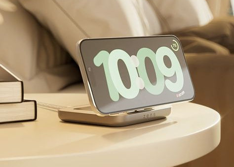 Magnetic nightstand charger wirelessly charging an iPhone displaying a clock on a bedside table in a bedroom