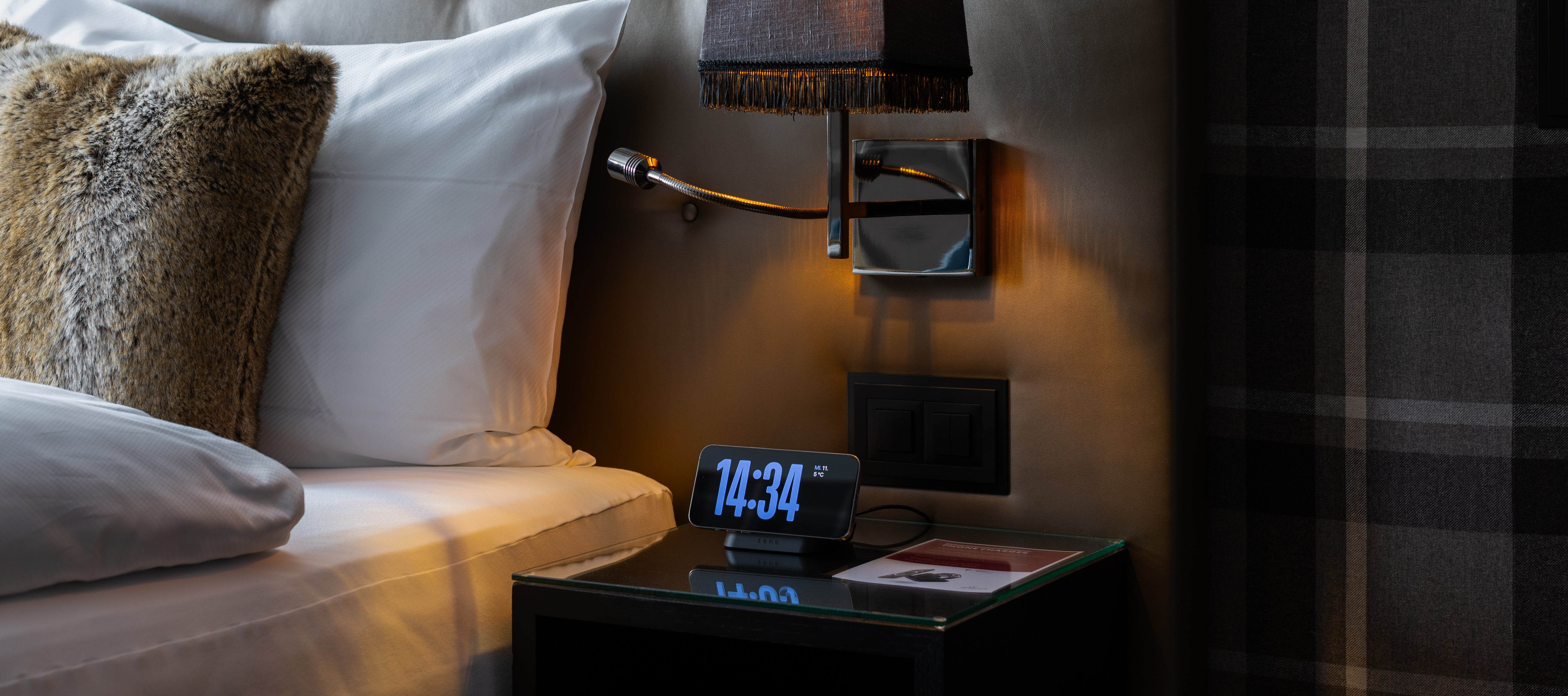 Magnetic nightstand wireless charger with clock charging an iPhone on a nightstand