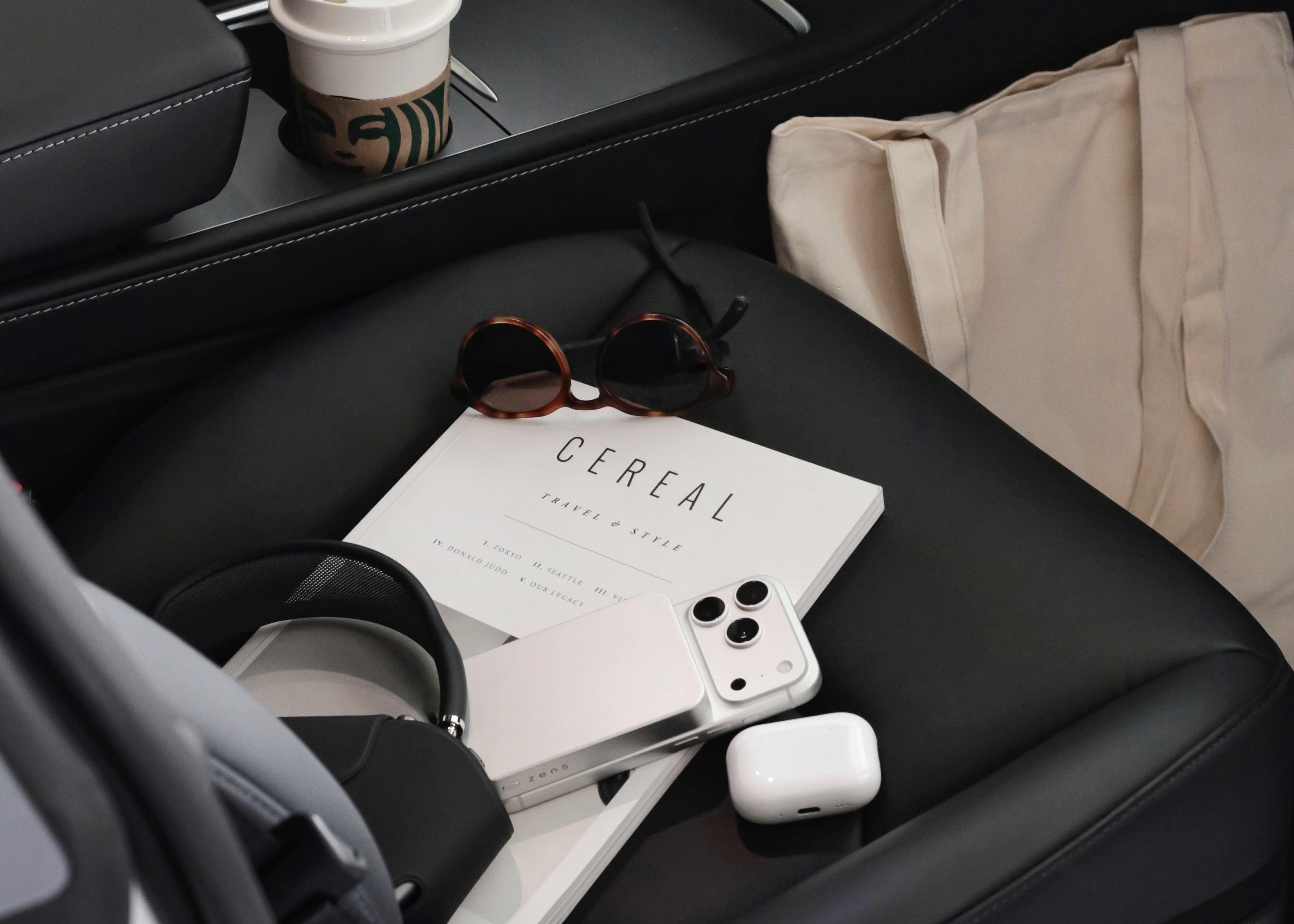 White Zens Magnetic Powerbank Pro charging a white iPhone on a car seat